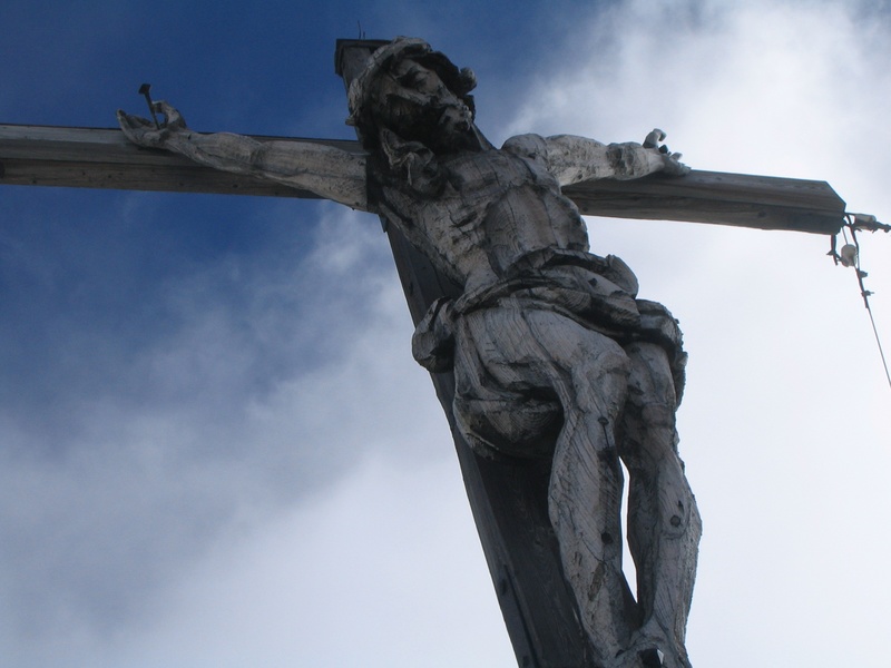 Handgeschnitzter Christus am Gipfelkreuz des Piz Miaras.