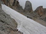 Anna beim Queren eines Schneefeldes kurz nach dem Felsfenster. Im Hintergrund eine alte Festungsruine.